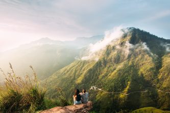 The couple greets the sunrise in the mountains. Man and woman in the mountains. Wedding travel